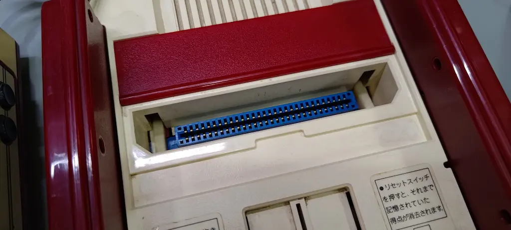 前期型ファミコンの青いカードエッジコネクタが見えるカセット差込口